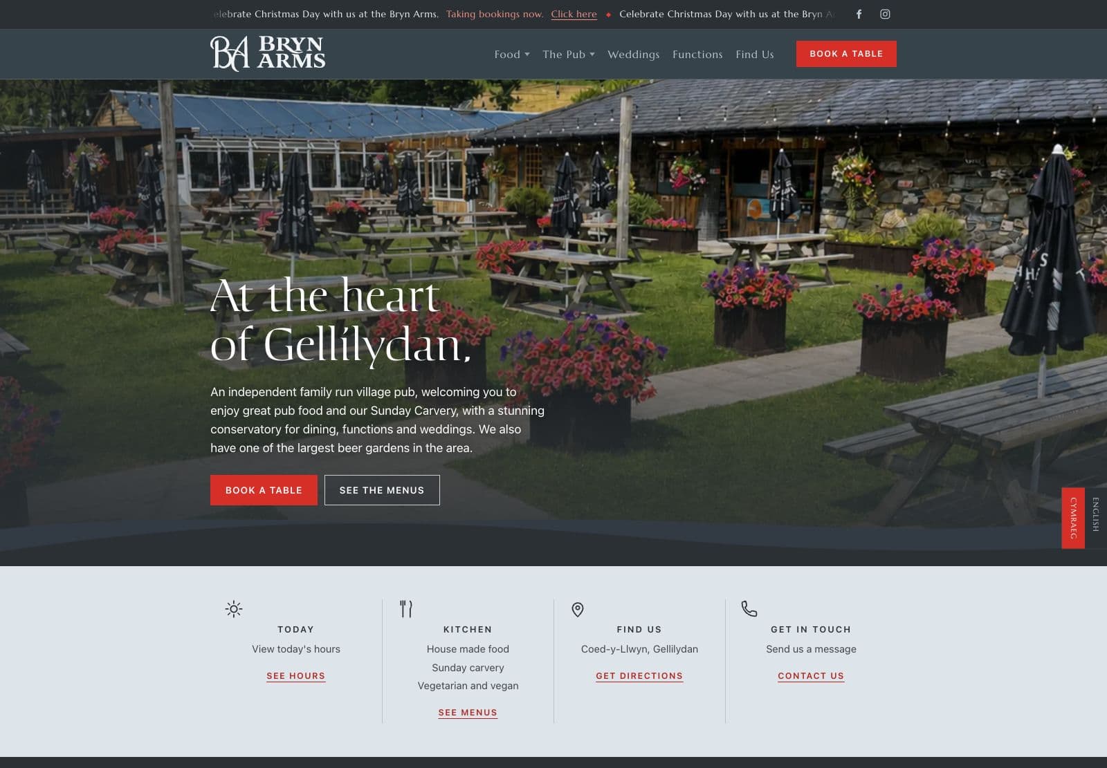The Bryn Arms website homepage, slate grey with a white serif logo and a red Book a table button over a photograph of the beer garden